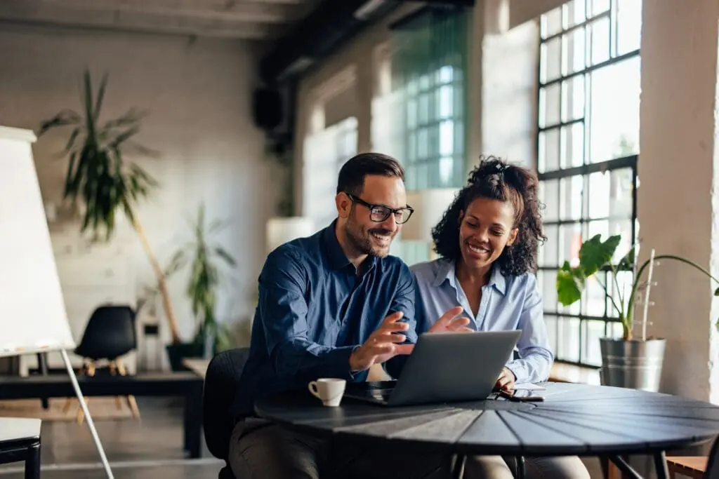 Smiling businessman showing a new project to his female colleague | TotalSDS® compliance for new businesses