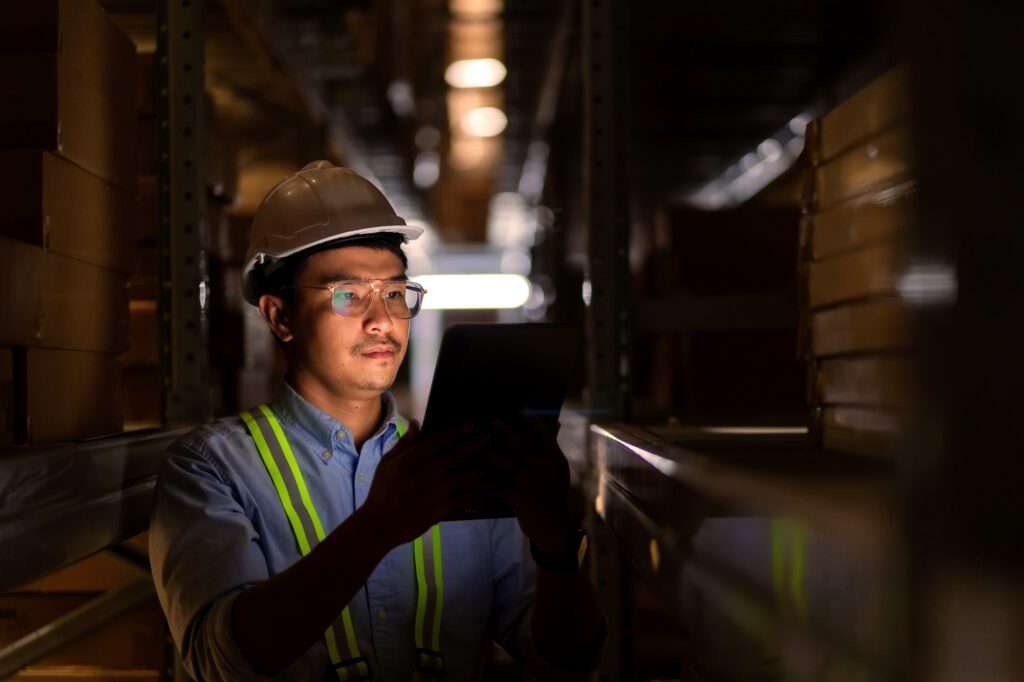 Safety professional using a digital tablet to manage chemical compliance in an industrial facility.